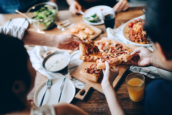 a group of people eating pizza