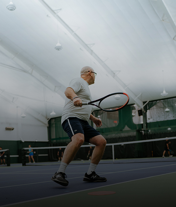 an older man playing tennis