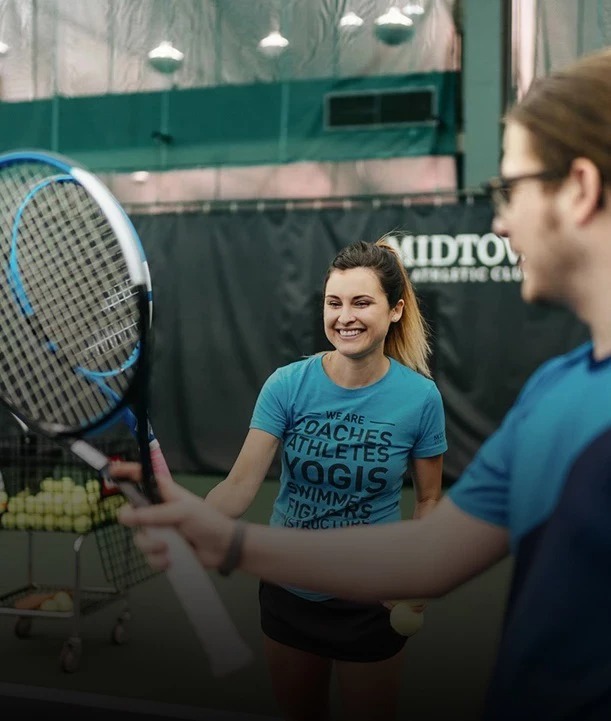 a woman holding a tennis racket and a man in a tennis court