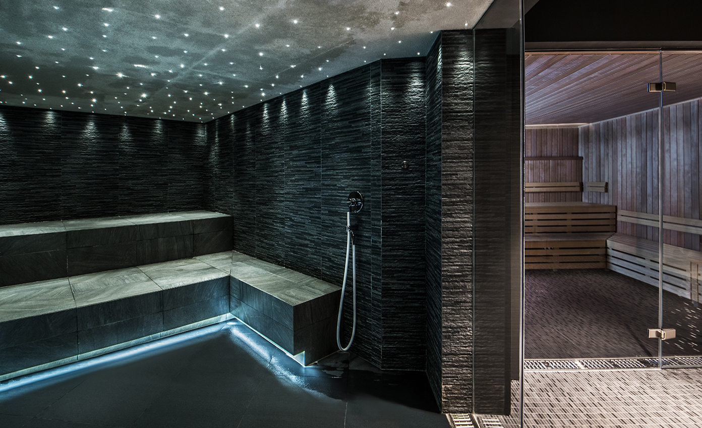 a black and white room with a shower and a bench