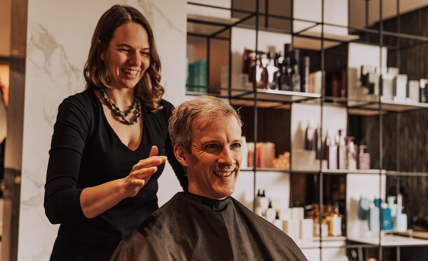 a woman standing next to a man's haircut