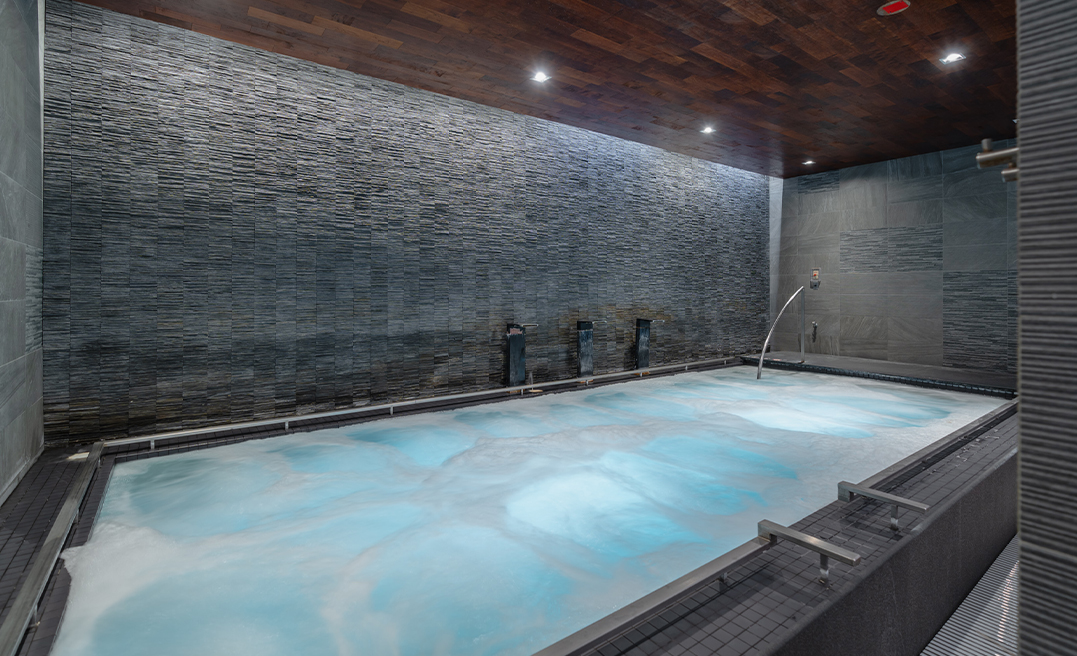 a large indoor pool with a large stone wall