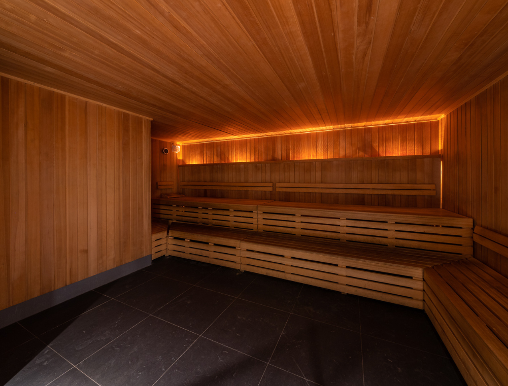 a wooden room with benches and a black tile floor