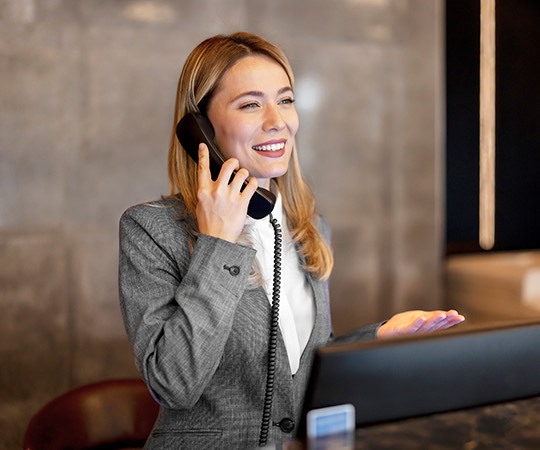 a concierge smiling and talking on the phone