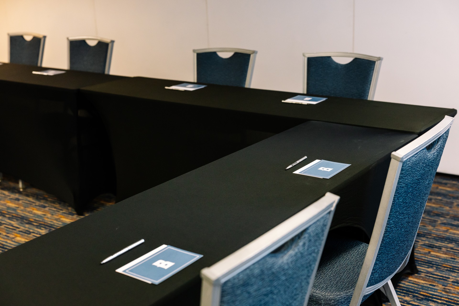 a table with black tablecloths and pen on it