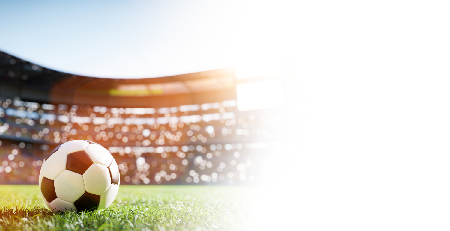 a football ball on grass in front of a stadium