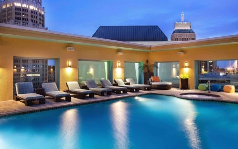 Swimming pool area with couple of pool chair around of the property