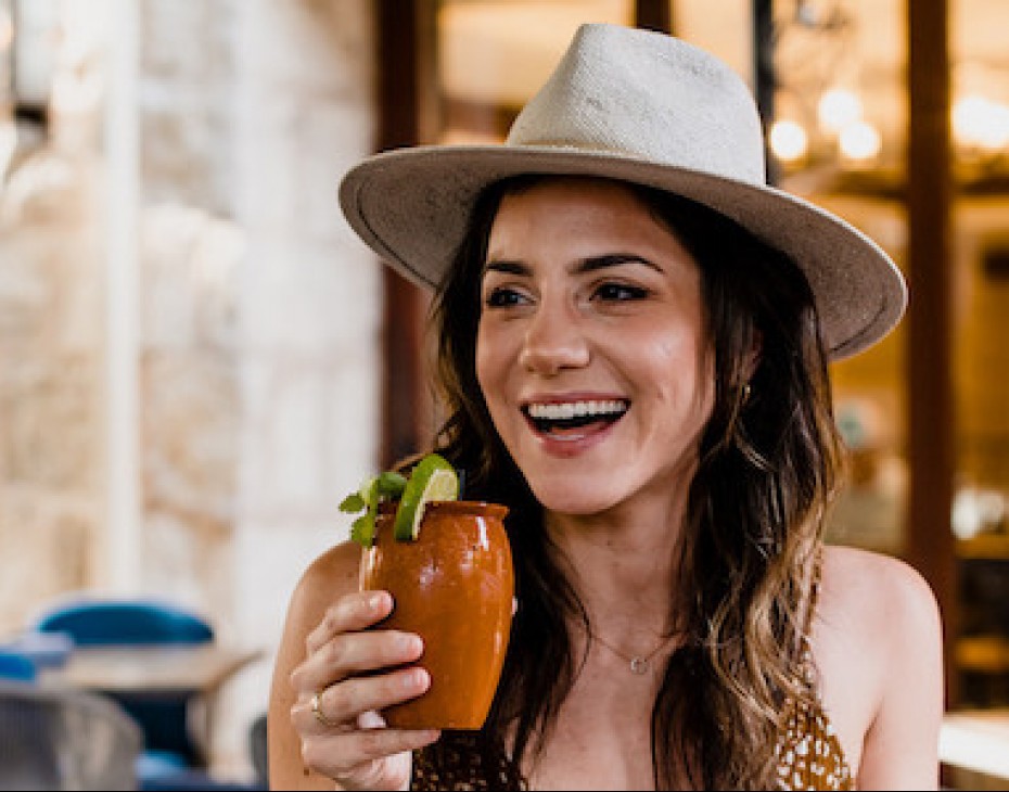 woman smiling holding a drink