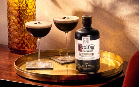 a bottle of espresso martini and two glasses of espresso martini on a tray