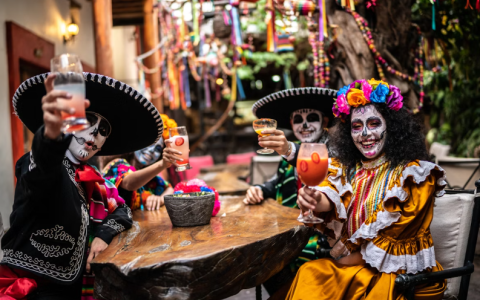 a group of people wearing face paint and holding drinks