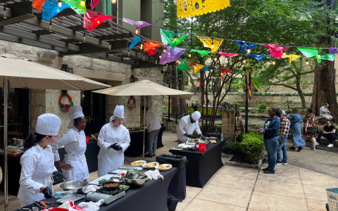 a group of people in white uniforms cooking food