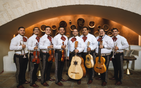 a group of men wearing white shirts and holding musical instruments