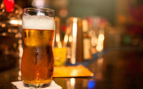 a glass of beer on a bar