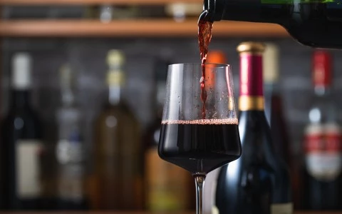 a glass of red wine being poured