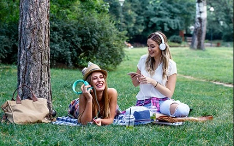 two women sitting on the grass