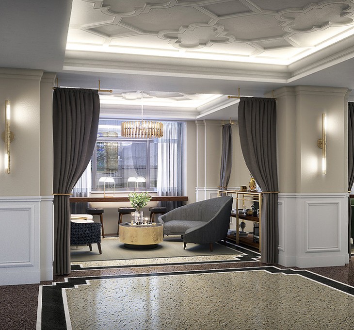 A gray colored sofa with a small round table and soft lighting from a chandelier hanging above.