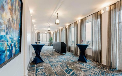 a long room with tables and a table with a black cabinet
