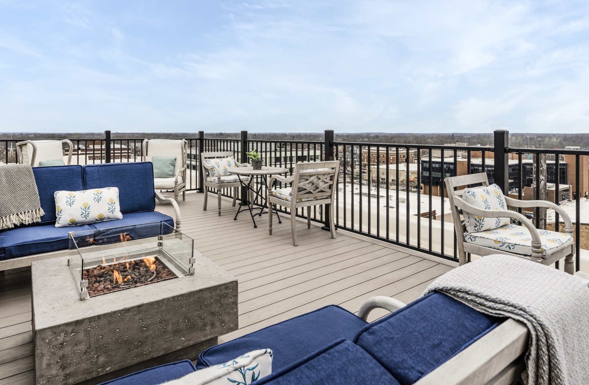 a patio with chairs and a fire pit