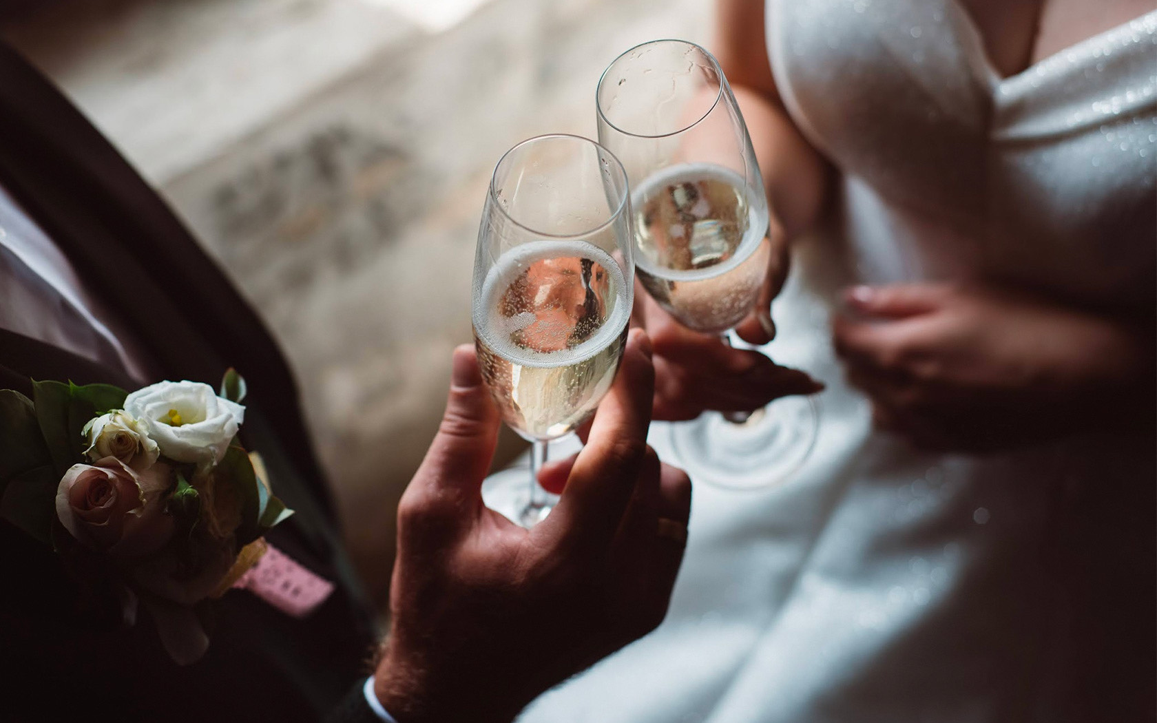 A bride and groom clinking their champagne glasses.