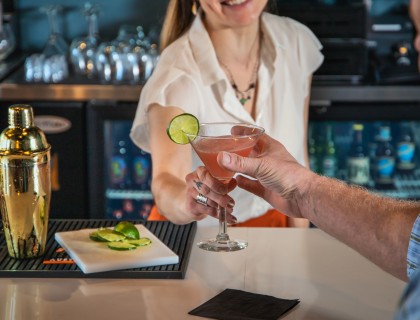 a hand holding a glass of pink liquid