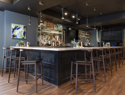 a bar with a black counter and stools