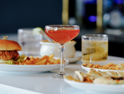 a glass of drink and food on a table