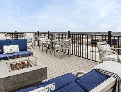 a patio with chairs and a fire pit