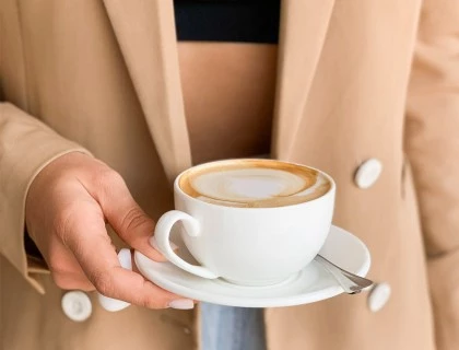 a woman holding a cappuccino