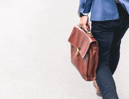 a person holding a brown leather briefcased