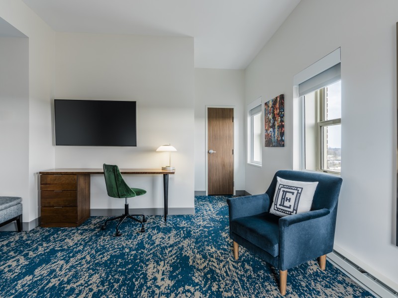 a room with a blue chair and a desk