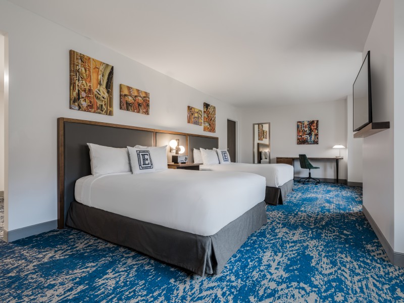 a room with two beds and a blue carpet