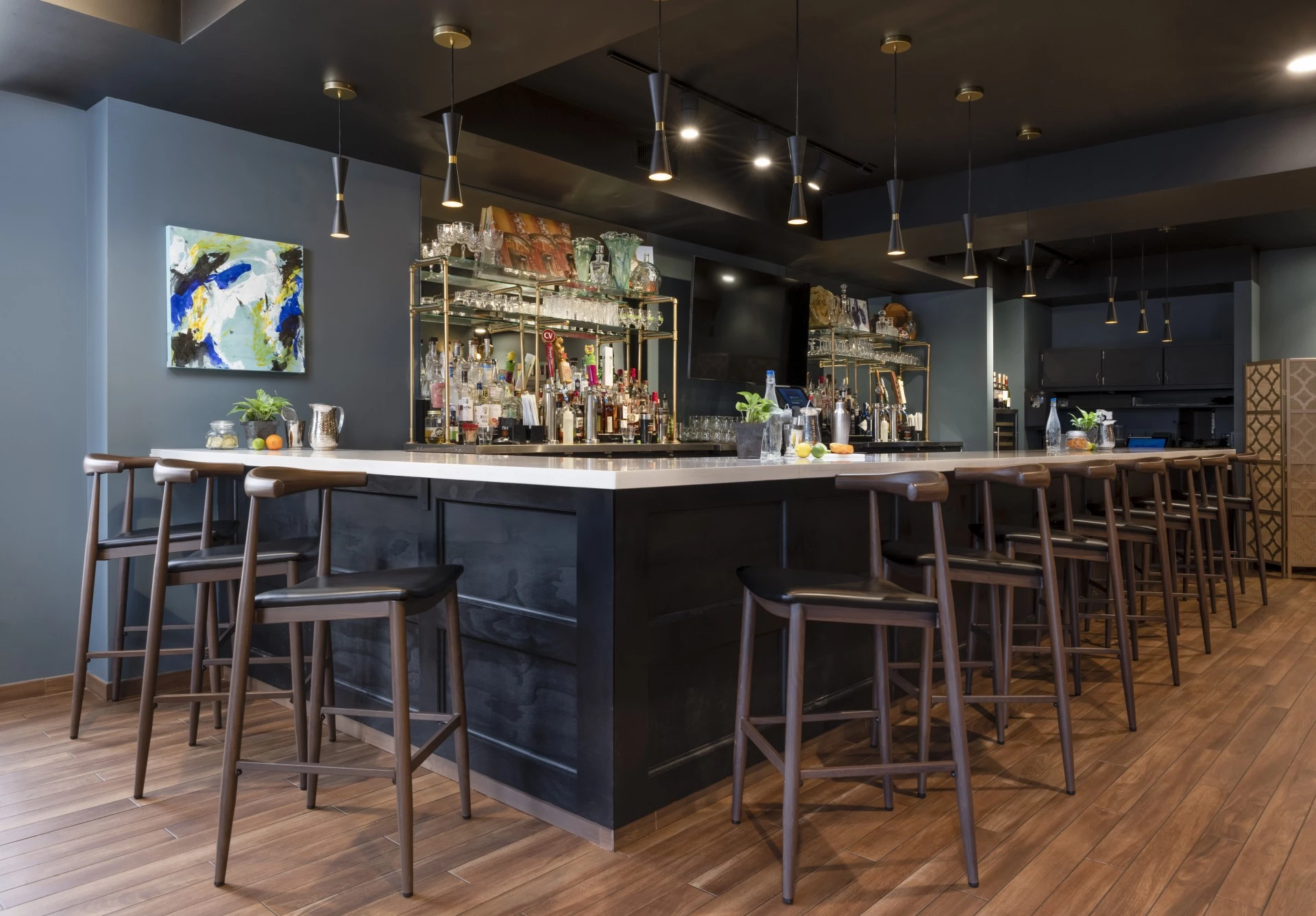 a bar with a black counter and stools