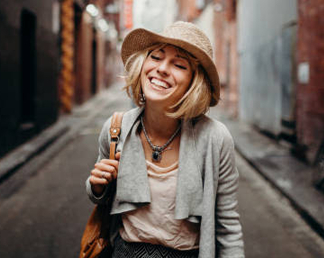 a woman with blonde hair in a hat smiling