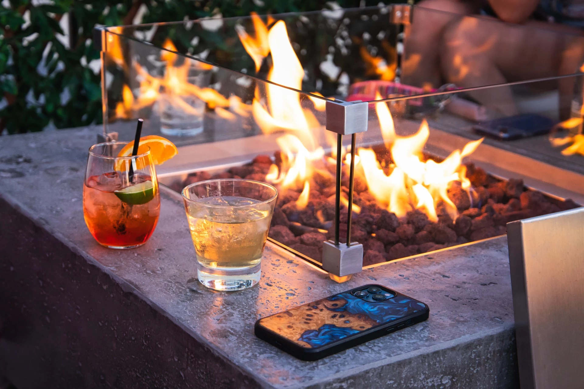 a fire pit with drinks and a cell phone