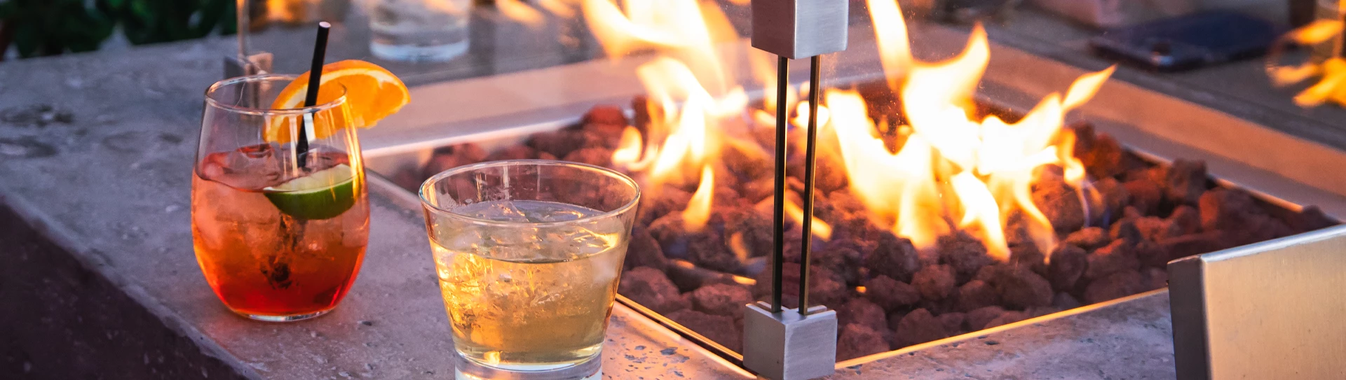 a glass of liquid next to a fire