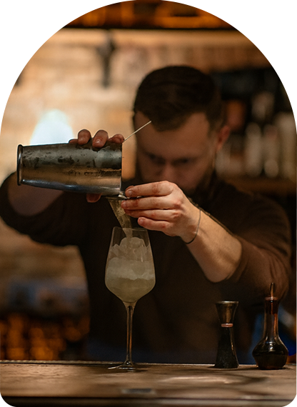 a man pouring a drink into a glass