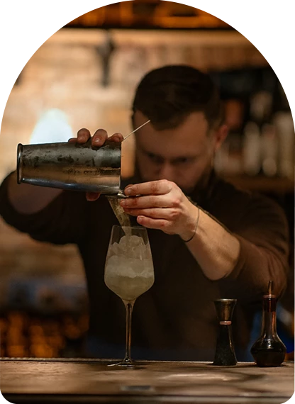 a man pouring a drink into a glass
