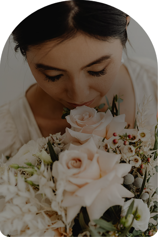 a woman smelling a bouquet of flowers