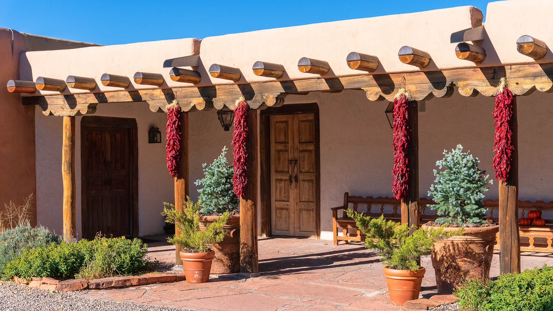 a building with a wooden porch and red chili peppers from it