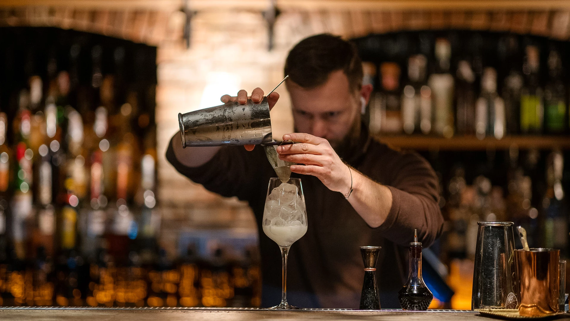 a man pouring a drink into a glass