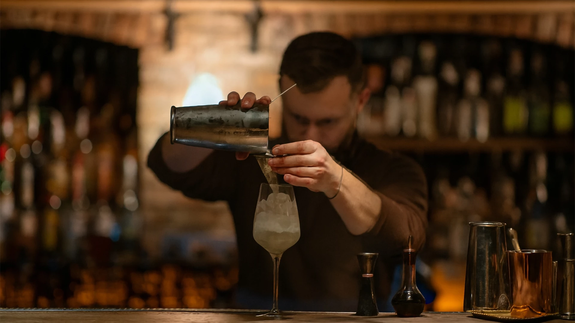a man pouring a drink into a glass