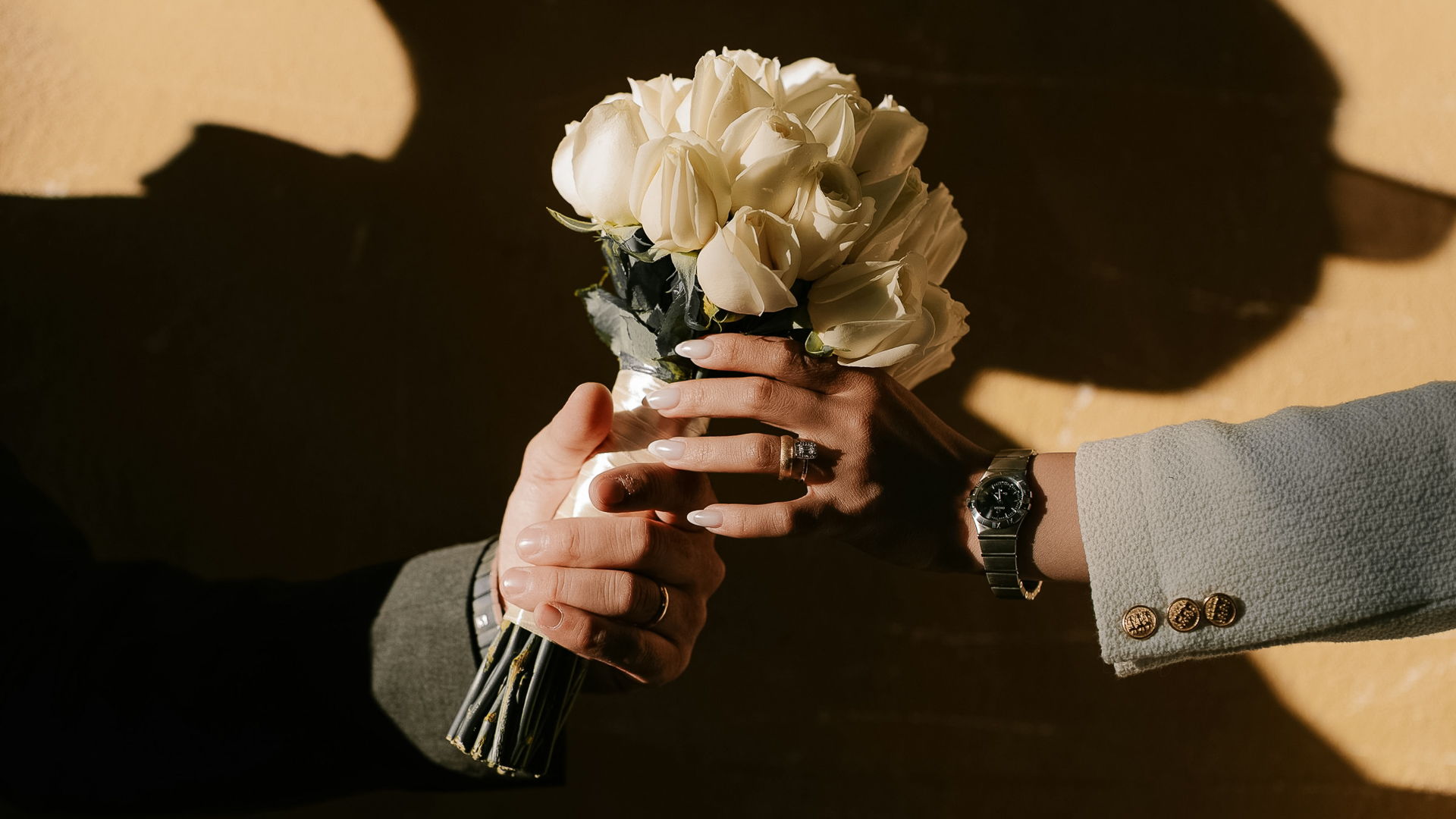 a hand holding a bouquet of white roses