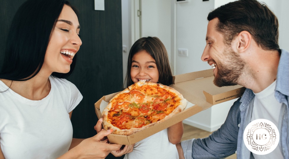 a man and woman holding a pizza