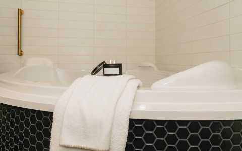 a candle and towel on a bathtub