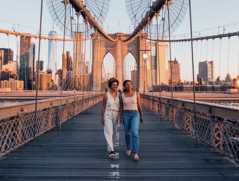two women walking on a bridge