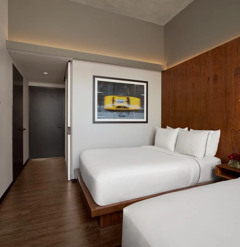 a room with two beds and a wood paneled wall 