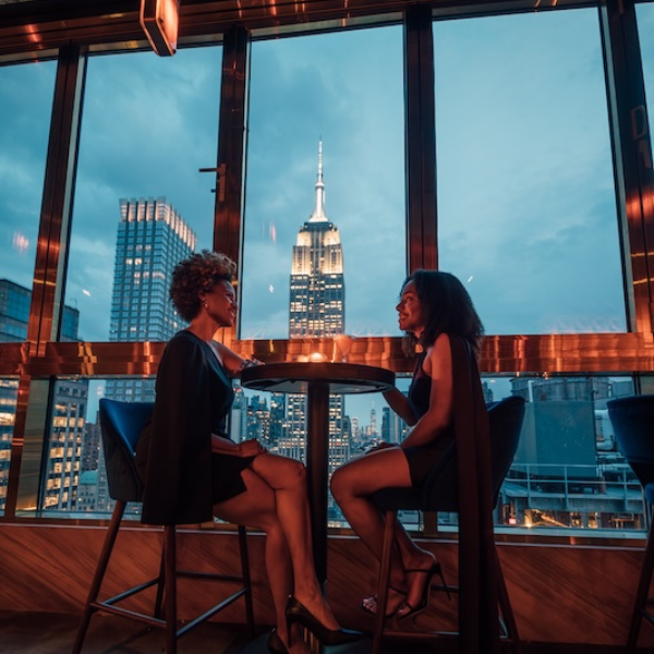two women sitting at a table in front of a window