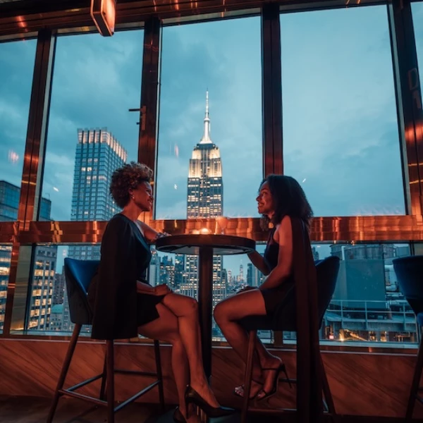 two women sitting at a table in front of a window