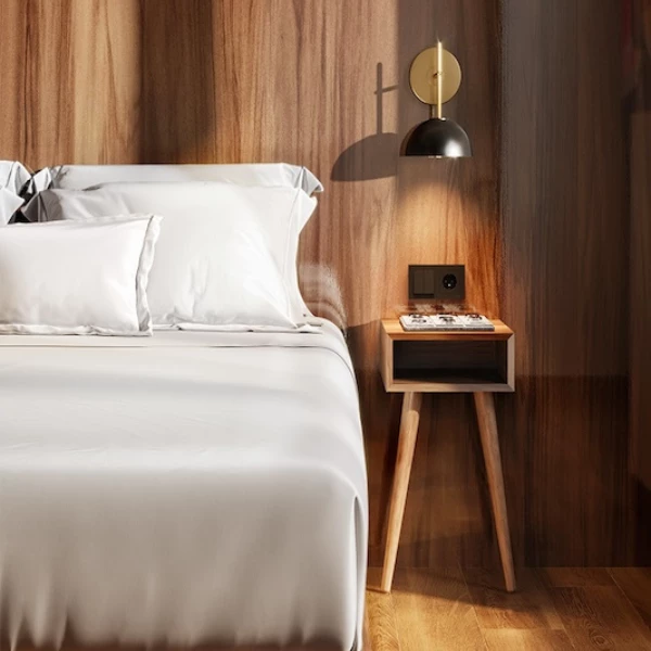 a bed with white sheets and a wood wall