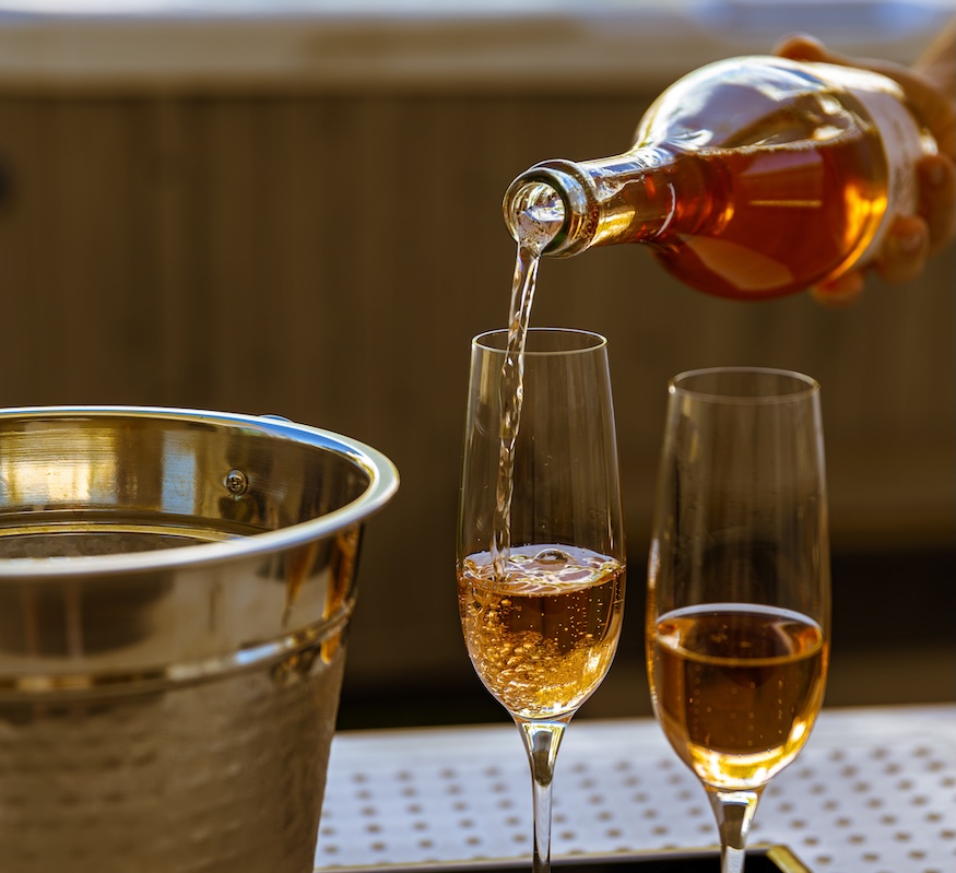 a person pouring a drink into a glass